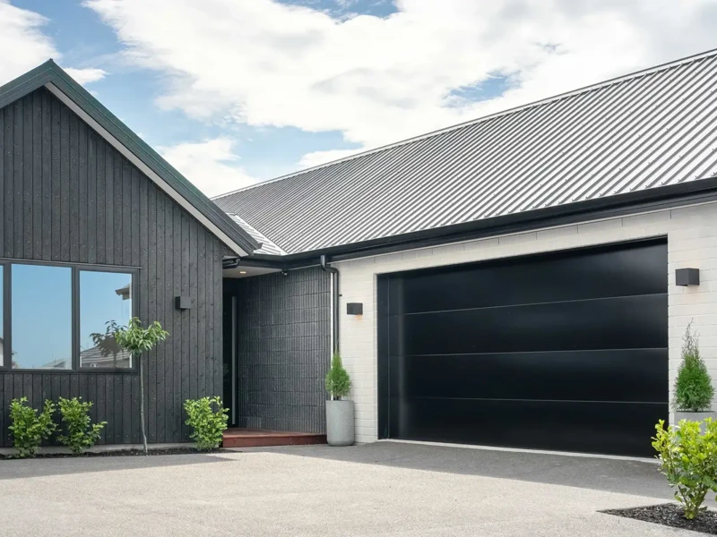 Modern single-story home with a black wooden exterior and garage door | Classic Builders